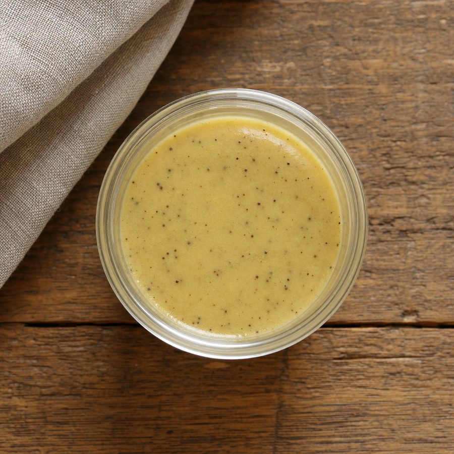 Small jar of pale yellow mustard slaw dressing